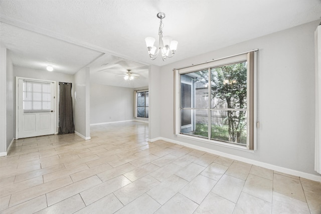 empty room with ceiling fan with notable chandelier and a textured ceiling