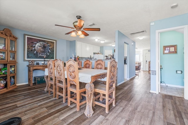 dining room with ceiling fan, wood-type flooring, and a textured ceiling