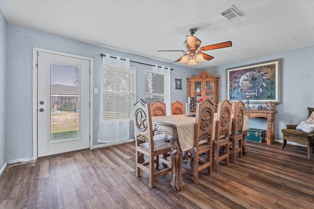 dining area with a textured ceiling, ceiling fan, and dark wood-type flooring