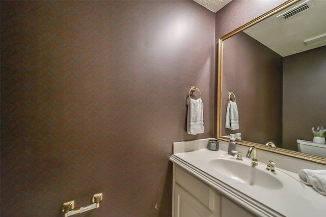 bathroom featuring vanity and toilet