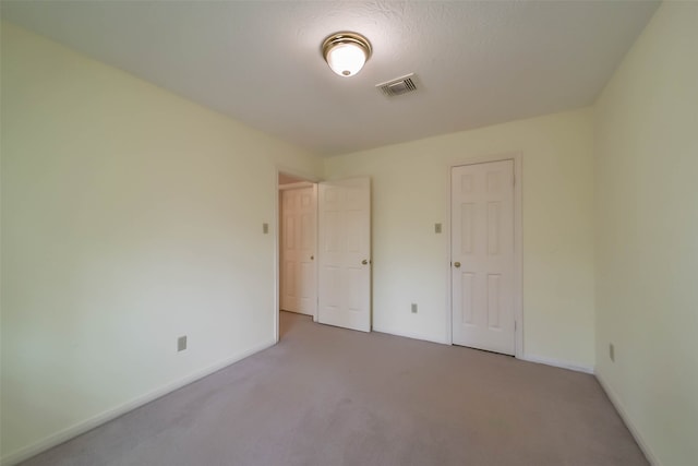 unfurnished bedroom featuring carpet, a textured ceiling, and a closet