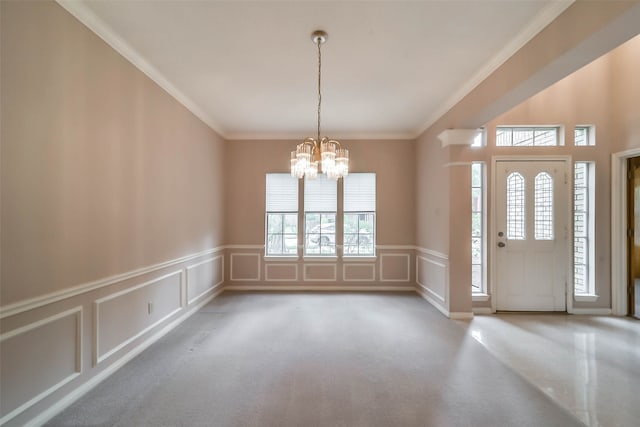 foyer with crown molding and an inviting chandelier