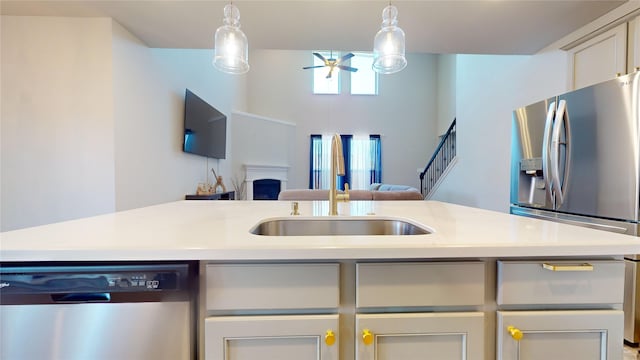 kitchen with pendant lighting, ceiling fan, sink, and appliances with stainless steel finishes