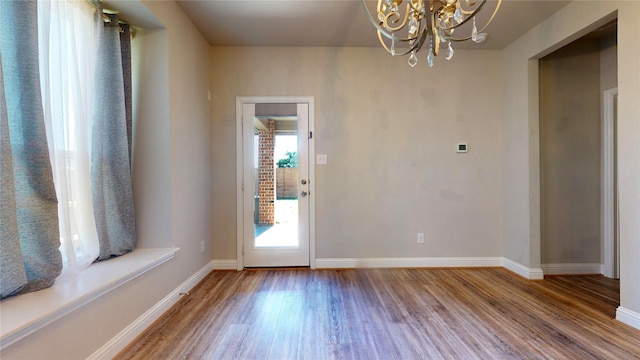 doorway to outside featuring hardwood / wood-style flooring and a chandelier