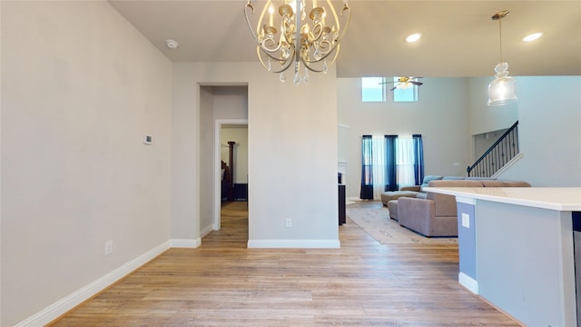 unfurnished dining area with light hardwood / wood-style flooring and ceiling fan with notable chandelier