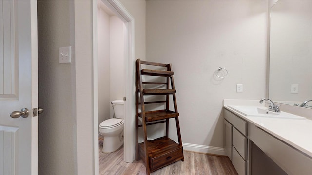 bathroom with hardwood / wood-style floors, vanity, and toilet