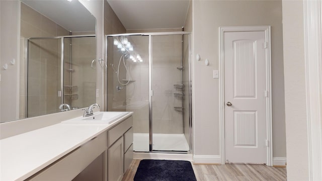 bathroom featuring a shower with door, vanity, and wood-type flooring