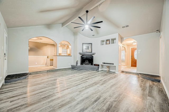 unfurnished living room featuring light wood-type flooring, vaulted ceiling with beams, and ceiling fan