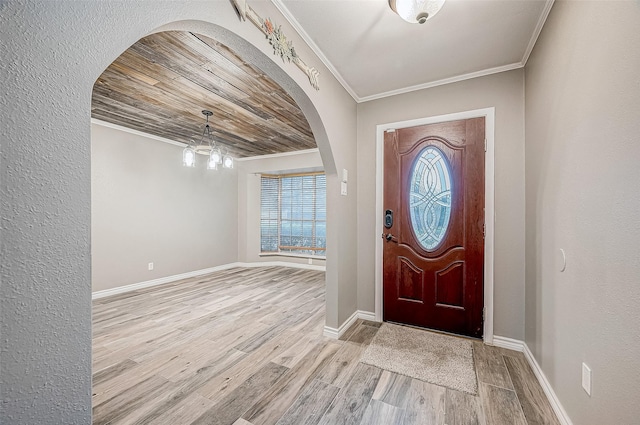 entrance foyer featuring a chandelier, crown molding, wood ceiling, and light wood-type flooring