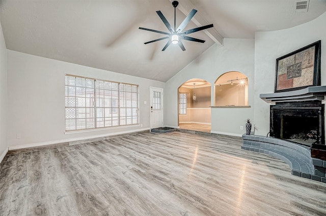 unfurnished living room with ceiling fan, hardwood / wood-style floors, beamed ceiling, and high vaulted ceiling