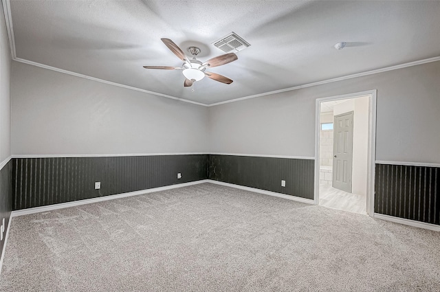 empty room with light colored carpet, ceiling fan, and ornamental molding