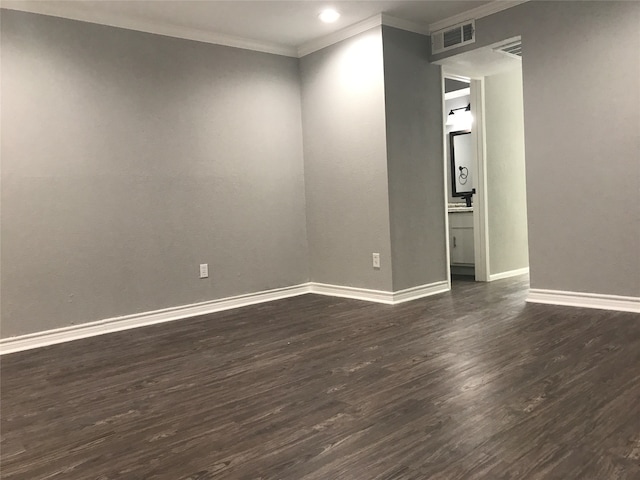 spare room featuring dark hardwood / wood-style flooring and crown molding