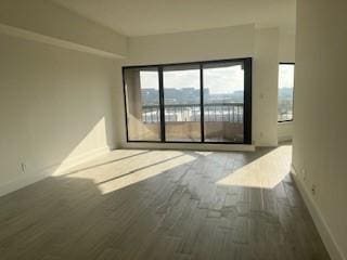 unfurnished room with dark hardwood / wood-style flooring