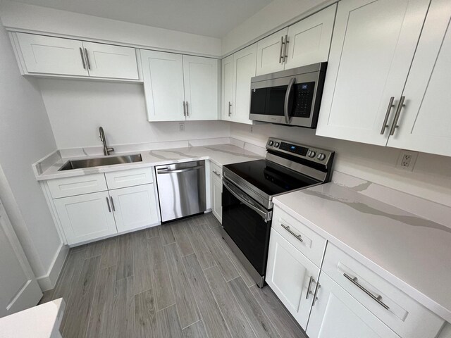 kitchen with sink, white cabinets, and appliances with stainless steel finishes