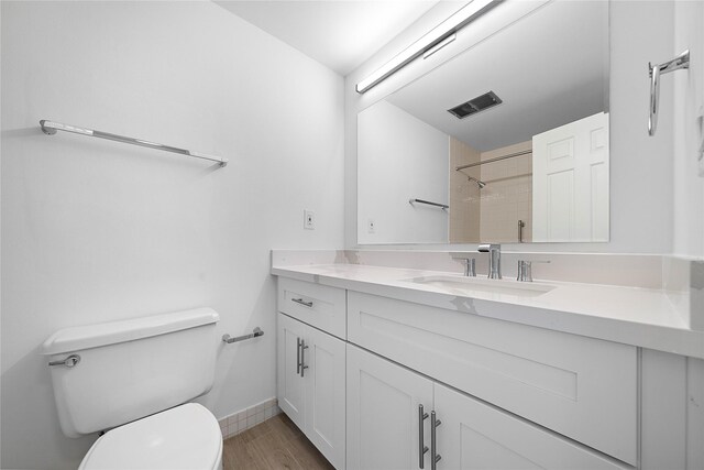 2001 Holcombe Blvd Unit 705, Houston, TX 77030 - bathroom featuring toilet, vanity, a shower, wood finished floors, and baseboards