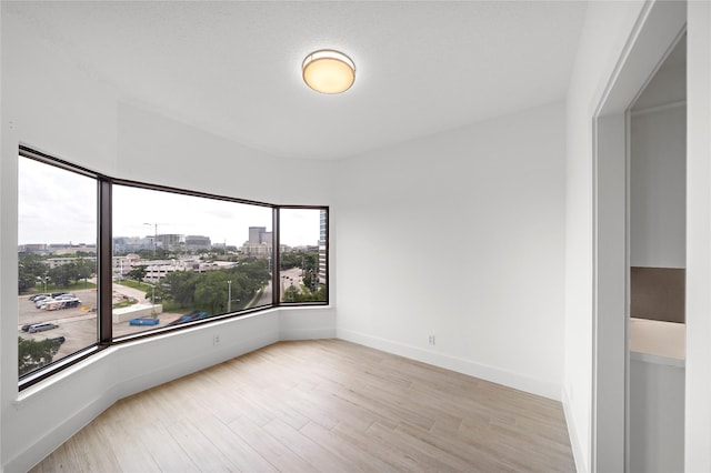 2001 Holcombe Blvd Unit 705, Houston, TX 77030 - spare room featuring plenty of natural light, wood finished floors, a view of city, and baseboards