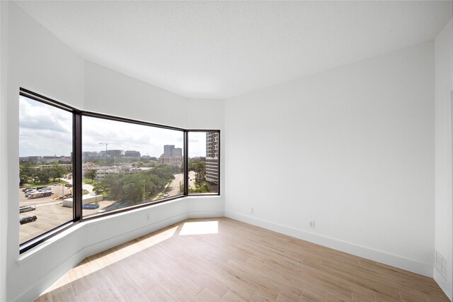 2001 Holcombe Blvd Unit 705, Houston, TX 77030 - unfurnished room featuring wood finished floors, baseboards, and a view of city