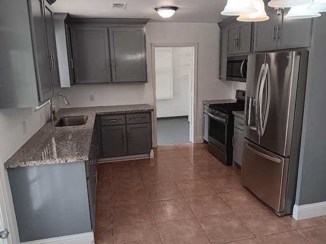 kitchen featuring gray cabinets, sink, appliances with stainless steel finishes, and dark stone counters