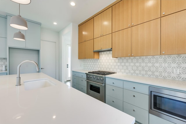 kitchen featuring tasteful backsplash, pendant lighting, sink, and stainless steel appliances