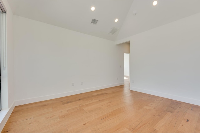 empty room featuring light wood-type flooring and high vaulted ceiling