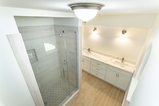 bathroom featuring vanity, hardwood / wood-style flooring, and a shower with door