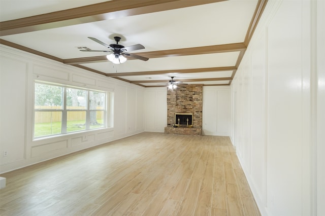 unfurnished living room with ceiling fan, a fireplace, beamed ceiling, and light wood-type flooring