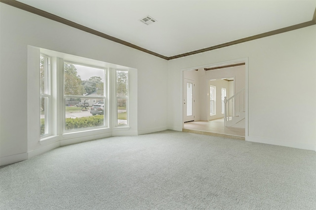 empty room with ornamental molding and light carpet