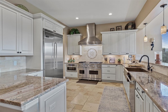 729 Pegasus Ln, League City, TX 77573 - kitchen with tasteful backsplash, high quality appliances, wall chimney exhaust hood, white cabinets, and a peninsula