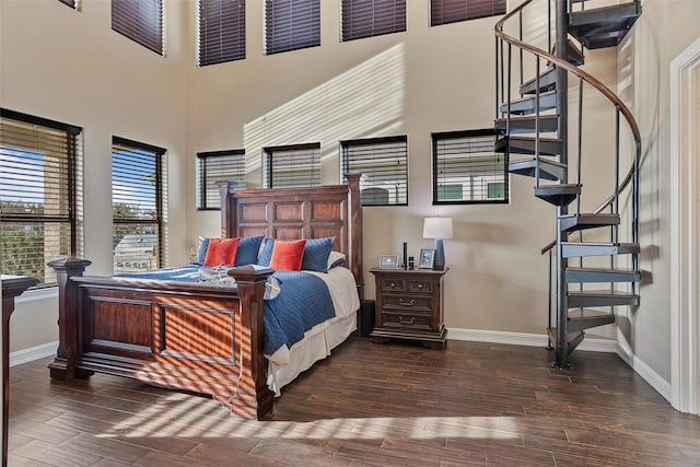 bedroom with a high ceiling and dark hardwood / wood-style floors