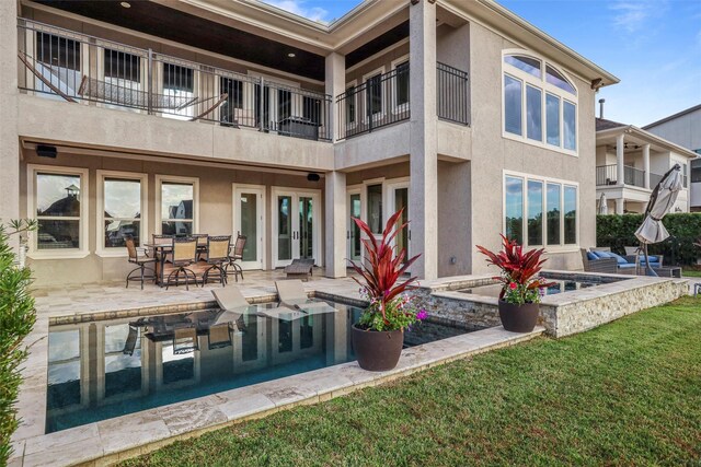 729 Pegasus Ln, League City, TX 77573 - rear view of property with stucco siding, a lawn, a balcony, and a patio