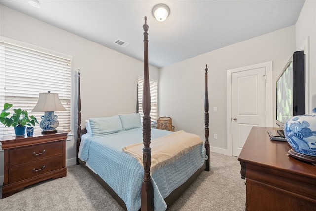 bedroom with multiple windows and light colored carpet