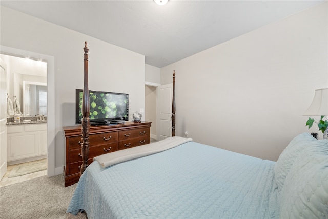 bedroom featuring connected bathroom and light colored carpet