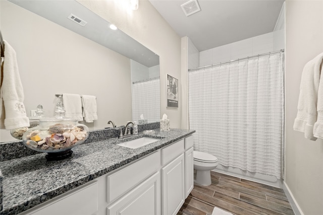 full bathroom with hardwood / wood-style floors, vanity, toilet, and shower / tub combo with curtain