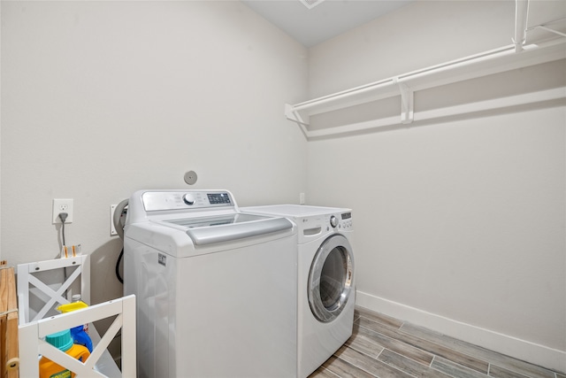 laundry room featuring separate washer and dryer and light hardwood / wood-style flooring