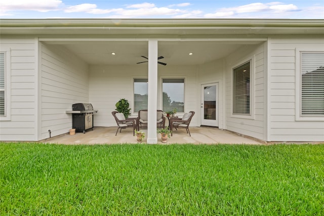 back of house featuring a lawn, ceiling fan, and a patio