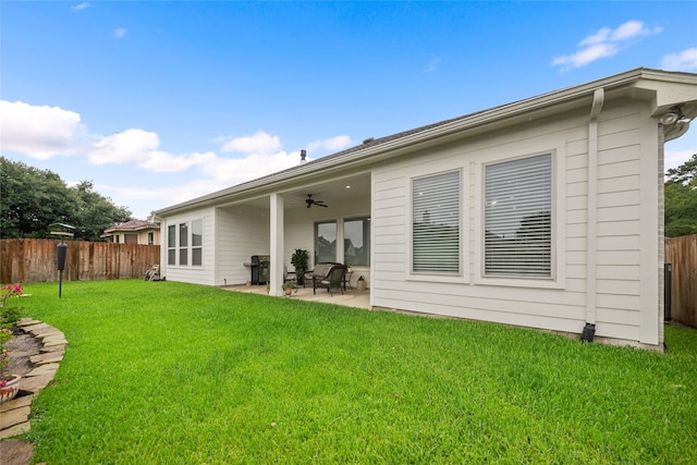 rear view of house with a yard, a ceiling fan, fence private yard, and a patio area
