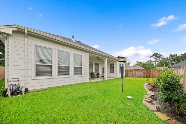 rear view of house featuring a yard, ceiling fan, and a patio area