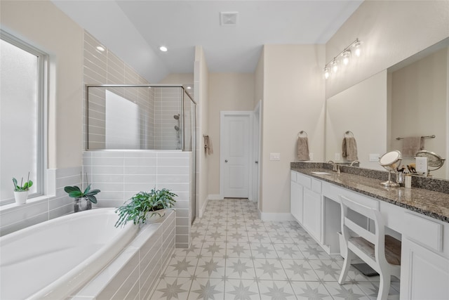 bathroom with vanity and shower with separate bathtub