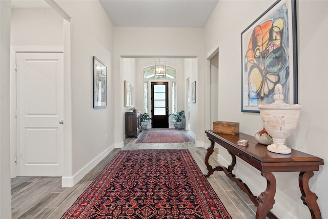 foyer entrance with light wood-type flooring and a chandelier