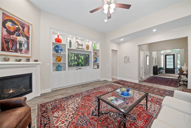 living room with ceiling fan and light wood-type flooring