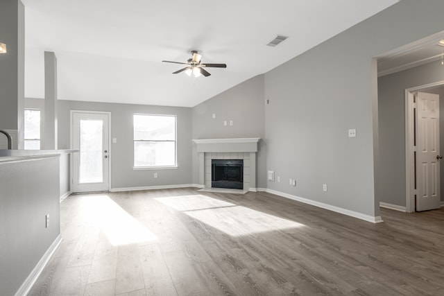 unfurnished living room featuring ceiling fan, wood-type flooring, lofted ceiling, and a fireplace