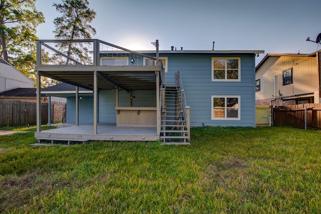 back of property featuring a yard and a wooden deck