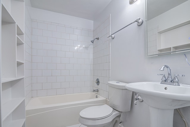 bathroom featuring tiled shower / bath combo and toilet