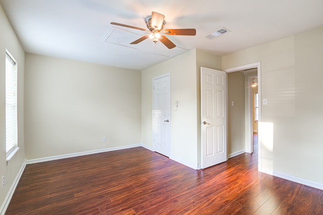 unfurnished bedroom featuring multiple windows, dark hardwood / wood-style floors, and ceiling fan