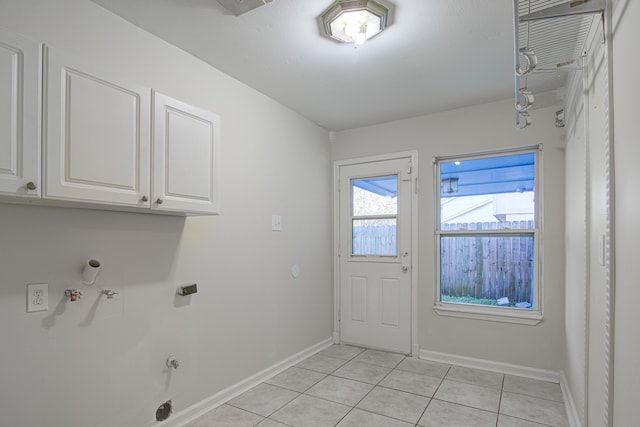 laundry area with cabinets, light tile patterned floors, and hookup for a gas dryer