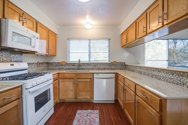 kitchen with decorative backsplash, dark hardwood / wood-style flooring, white appliances, and sink