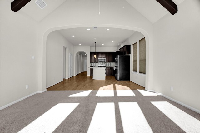 unfurnished living room with wood-type flooring and vaulted ceiling