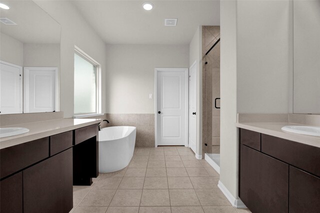 bathroom featuring tile patterned flooring, vanity, tile walls, and independent shower and bath