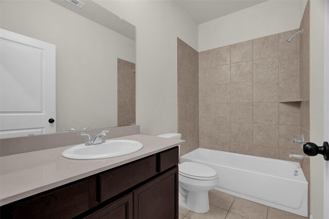 full bathroom featuring toilet, vanity, tiled shower / bath combo, and tile patterned floors