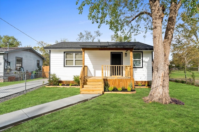 bungalow-style home with a wooden deck and a front lawn